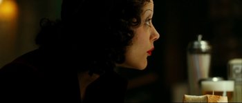 Movie still from “La Vie En Rose” (2007), directed by Olivier Dahan – A person wearing a black dress; Close Up shot, Over the shoulder angle