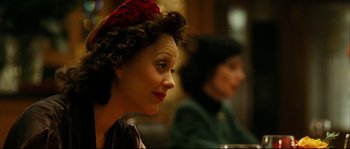 Movie still from “La Vie En Rose” (2007), directed by Olivier Dahan – Two women sitting in a room and one of them is wearing a red hat; Close Up shot, Over the shoulder angle