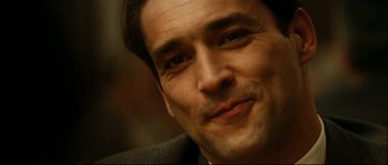Movie still from “La Vie En Rose” (2007), directed by Olivier Dahan – A man's face in a suit jacket; Close Up shot, Over the shoulder angle
