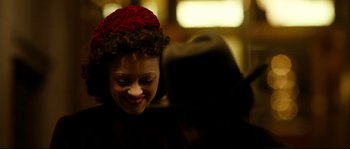 Movie still from “La Vie En Rose” (2007), directed by Olivier Dahan – A person wearing a red hat; Close Up shot, Over the shoulder angle