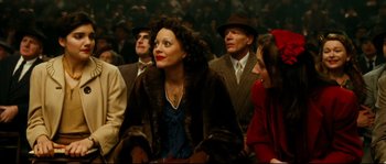 Movie still from “La Vie En Rose” (2007), directed by Olivier Dahan – A group of people sitting in a crowd wearing hats; Medium shot, High angle