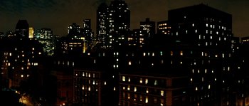 Movie still from “La Vie En Rose” (2007), directed by Olivier Dahan – A view of a city at night with lights on; Extreme Wide shot, High angle