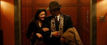 Movie still from “La Vie En Rose” (2007), directed by Olivier Dahan – A man and a woman are dressed in suits and hats; Medium shot, Overhead angle
