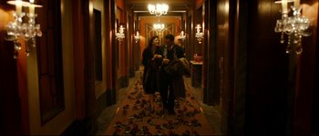 Movie still from “La Vie En Rose” (2007), directed by Olivier Dahan – A group of people walking down a hall way; Wide shot, High angle