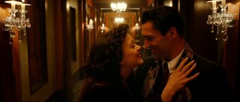 Movie still from “La Vie En Rose” (2007), directed by Olivier Dahan – A man and a woman are smiling in a hallway; Close Up shot, High angle