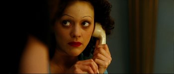 Movie still from “La Vie En Rose” (2007), directed by Olivier Dahan – A woman holding a phone up to her ear; Close Up shot, Overhead angle