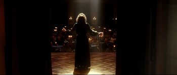 Movie still from “La Vie En Rose” (2007), directed by Olivier Dahan – A woman standing on a stage in front of an audience; Wide shot, Over the shoulder angle