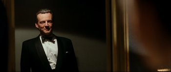 Movie still from “La Vie En Rose” (2007), directed by Olivier Dahan – A man in a tuxedo standing next to a wall; Medium shot, Low angle