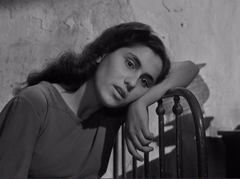 Movie still from “The Earth Trembles” (1948), directed by Luchino Visconti – Black and white photograph of a woman leaning on a railing; Close Up shot, High angle