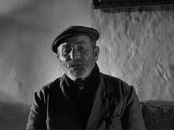 Movie still from “The Earth Trembles” (1948), directed by Luchino Visconti – An older man wearing a hat and a jacket; Close Up shot, Low angle