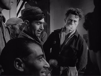 Movie still from “The Earth Trembles” (1948), directed by Luchino Visconti – A black and white photo of a group of men; Medium shot, Over the shoulder angle