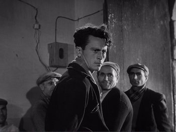 Movie still from “The Earth Trembles” (1948), directed by Luchino Visconti – A group of men standing next to each other; Medium shot, Low angle