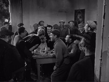 Movie still from “The Earth Trembles” (1948), directed by Luchino Visconti – A group of men sitting around a table; Wide shot, High angle