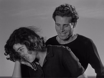 Movie still from “The Earth Trembles” (1948), directed by Luchino Visconti – A man and a woman standing next to each other; Medium shot, High angle