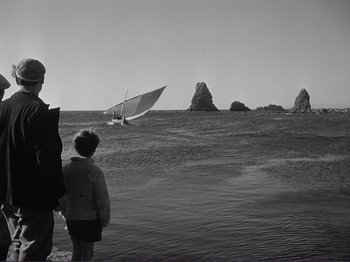 Movie still from “The Earth Trembles” (1948), directed by Luchino Visconti – A man and a child looking out to sea; Wide shot, High angle