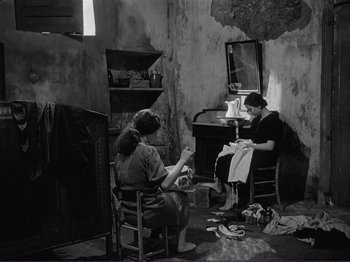 Movie still from “The Earth Trembles” (1948), directed by Luchino Visconti – A group of women sitting in a room; Wide shot, High angle