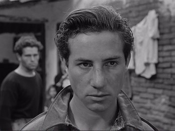 Movie still from “The Earth Trembles” (1948), directed by Luchino Visconti – A young man is looking into the camera; Close Up shot, Over the shoulder angle