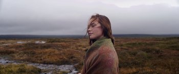 Movie still from “Lady Macbeth” (2016), directed by William Oldroyd – A woman wrapped in a blanket standing in a field; Close Up shot, Low angle