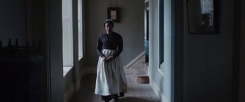 Movie still from “Lady Macbeth” (2016), directed by William Oldroyd – A woman standing in a room wearing a dress and a hat; Medium shot, Low angle