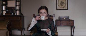 Movie still from “Lady Macbeth” (2016), directed by William Oldroyd – A woman sitting in a chair drinking a cup of coffee; Medium shot, Low angle