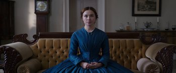 Movie still from “Lady Macbeth” (2016), directed by William Oldroyd – A woman in a blue dress sitting on top of a couch; Medium shot, Low angle