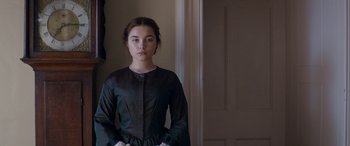 Movie still from “Lady Macbeth” (2016), directed by William Oldroyd – A woman in a black dress standing next to a white door; Medium shot, Over the shoulder angle