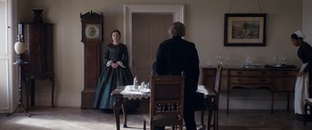 Movie still from “Lady Macbeth” (2016), directed by William Oldroyd – Two people sitting at a dining table in a room; Wide shot, Over the shoulder angle