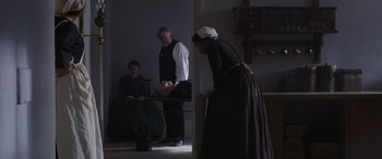 Movie still from “Lady Macbeth” (2016), directed by William Oldroyd – Three people in a room with a woman in a dress; Wide shot, Over the shoulder angle