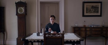 Movie still from “Lady Macbeth” (2016), directed by William Oldroyd – A woman sitting at a table with a cup of coffee; Medium shot, High angle