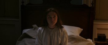 Movie still from “Lady Macbeth” (2016), directed by William Oldroyd – A woman in a white dress sitting on a bed; Close Up shot, High angle