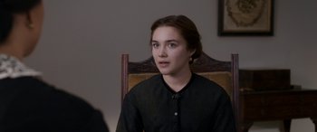 Movie still from “Lady Macbeth” (2016), directed by William Oldroyd – A woman sitting in a chair wearing a black shirt; Close Up shot, Over the shoulder angle