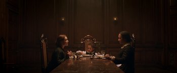 Movie still from “Lady Macbeth” (2016), directed by William Oldroyd – Three people sitting at a dinner table with a child; Medium shot, High angle