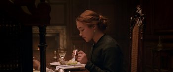 Movie still from “Lady Macbeth” (2016), directed by William Oldroyd – A woman sitting at a table eating a meal; Medium shot, Over the shoulder angle