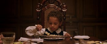 Movie still from “Lady Macbeth” (2016), directed by William Oldroyd – A young boy sitting at a table eating food from a plate; Close Up shot, High angle