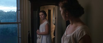 Movie still from “Lady Macbeth” (2016), directed by William Oldroyd – A woman standing in front of a mirror in front of a door; Medium shot, Over the shoulder angle