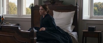 Movie still from “Lady Macbeth” (2016), directed by William Oldroyd – A woman sitting on a bed in a black dress; Medium shot, High angle
