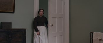 Movie still from “Lady Macbeth” (2016), directed by William Oldroyd – A woman standing in front of an open door; Medium shot, Low angle
