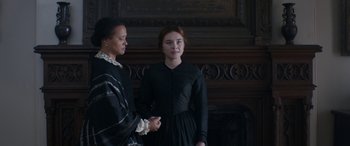Movie still from “Lady Macbeth” (2016), directed by William Oldroyd – Two women standing next to each other in front of a fireplace; Medium shot, Over the shoulder angle