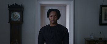 Movie still from “Lady Macbeth” (2016), directed by William Oldroyd – A woman in a black shirt is standing in front of a door; Medium shot, Low angle