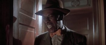Movie still from “Lady Sings the Blues” (1972), directed by Sidney J. Furie – An older man wearing a hat and a bow tie; Close Up shot, Low angle