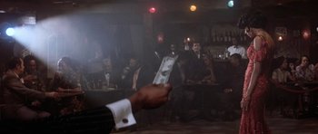Movie still from “Lady Sings the Blues” (1972), directed by Sidney J. Furie – A man that is holding money in his hand; Wide shot, Over the shoulder angle