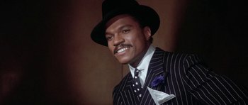 Movie still from “Lady Sings the Blues” (1972), directed by Sidney J. Furie – A man wearing a suit and a hat and smiling; Close Up shot, Low angle