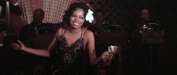Movie still from “Lady Sings the Blues” (1972), directed by Sidney J. Furie – A woman in a black and white dress holding money in her hand; Medium shot, Low angle