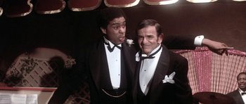 Movie still from “Lady Sings the Blues” (1972), directed by Sidney J. Furie – Two men in tuxedos posing for a picture; Medium shot, Low angle