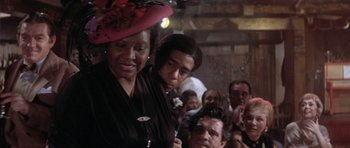 Movie still from “Lady Sings the Blues” (1972), directed by Sidney J. Furie – A group of people gathered in a room; Close Up shot, Over the shoulder angle
