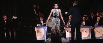 Movie still from “Lady Sings the Blues” (1972), directed by Sidney J. Furie – A woman standing on a stage holding a microphone; Medium shot, High angle