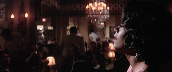 Movie still from “Lady Sings the Blues” (1972), directed by Sidney J. Furie – A woman is smiling in a room full of people; Close Up shot, Low angle