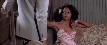 Movie still from “Lady Sings the Blues” (1972), directed by Sidney J. Furie – A woman in a pink dress sitting next to a man in a gray suit; Medium shot, Over the shoulder angle