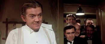 Movie still from “Lady Sings the Blues” (1972), directed by Sidney J. Furie – A group of men standing next to each other in front of a wall; Close Up shot, Over the shoulder angle