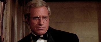 Movie still from “Lady Sings the Blues” (1972), directed by Sidney J. Furie – A man in a suit and tie wearing glasses; Close Up shot, Over the shoulder angle